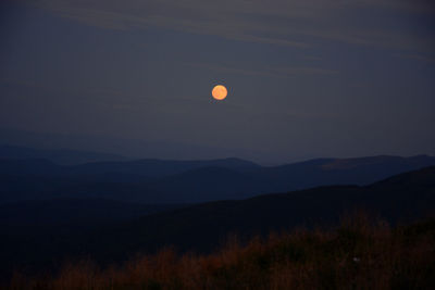 Scenic view of silhouette mountains against sky at night