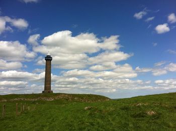 Low angle view of waterloo monument on hill against cloudy sky