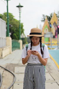 Woman using mobile phone against sky