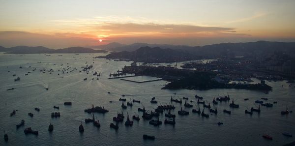 Boats moored in calm sea at sunset