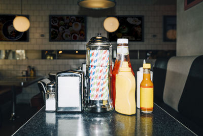 Drinking straw and bottles on table in restaurant