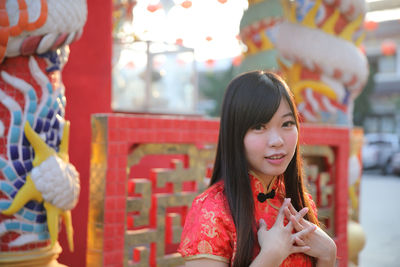 Portrait of a smiling young woman holding camera