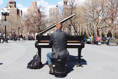 Rear view of man playing piano