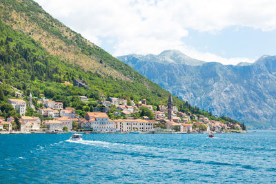 Houses by sea and mountains against sky at kotor bay against sky