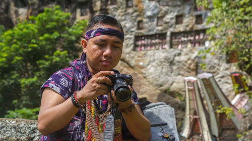 Young man photographing with camera