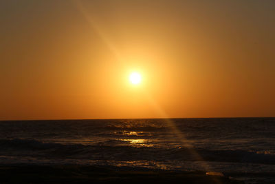 Scenic view of sea against orange sky