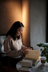 Young woman using mobile phone while sitting at home