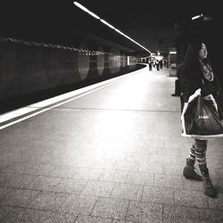 Full length of woman standing on escalator