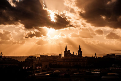 View of buildings in city at sunset