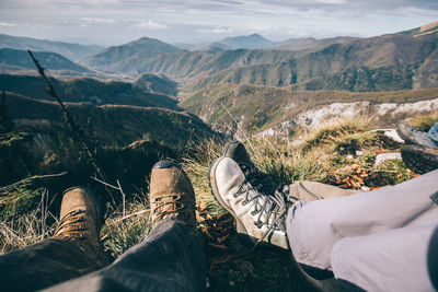 Low section of friends relaxing on mountain