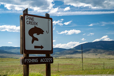 Information sign on landscape against sky