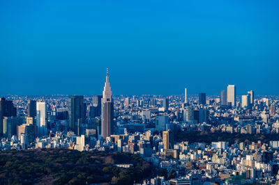 Modern buildings in city against blue sky