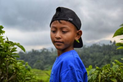 Portrait of boy looking at camera against sky