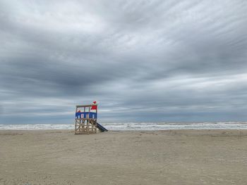 Lifeguard hut on beach against sky