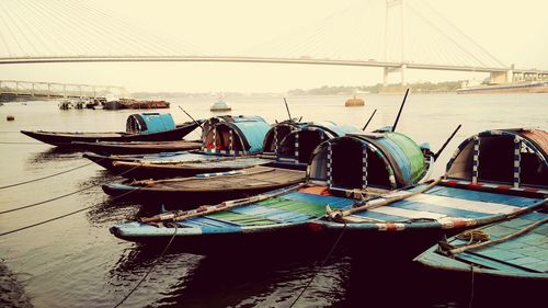 Boats moored on river against clear sky