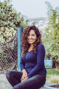 Portrait of smiling woman sitting outdoors