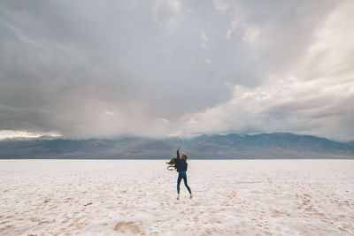 Full length of man standing on beach against sky