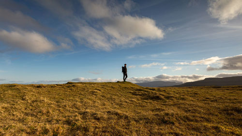 Man standing on field against sky