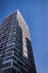 Low angle view of modern building against clear blue sky