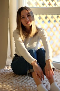 Portrait of young woman sitting at home