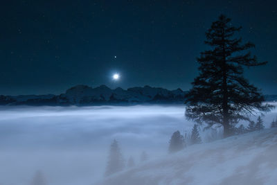 Scenic view of snowcapped mountains against sky at night