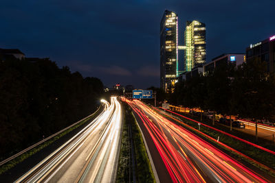 Light trails on road against sky at night