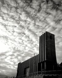 Low angle view of modern building against cloudy sky