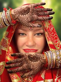 Close-up portrait of bride in sari showing henna tattoo