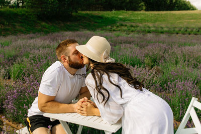 Close up of happy couple sitting near table  in lavender field 