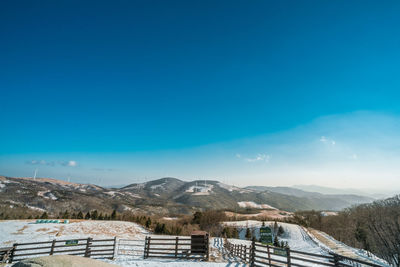 Scenic view of snowcapped mountains against blue sky