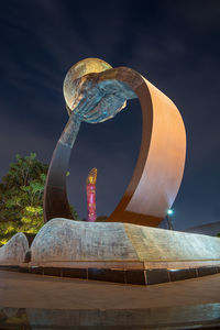 Hands rising from a book support the globe in this sculpture at qatar's aspire academy in doha.