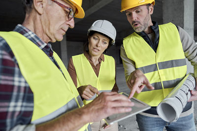 Rear view of people working at construction site