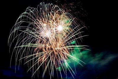 Low angle view of firework display against sky at night