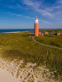 Lighthouse by sea against sky