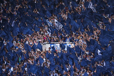 
argentine soccer fans wave blue flags during a soccer match in a stadium.
 high angle view of crowd