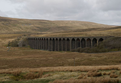 Viaduct in hills against sky