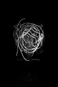 Close-up of illuminated light bulb against black background