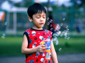 Portrait of cute girl with toy standing at park