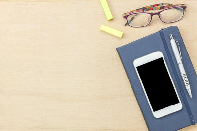 Close-up of smart phone with diary on table