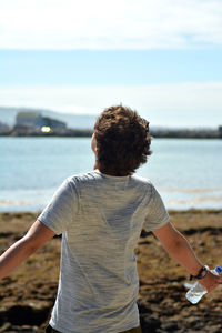 Rear view of a man standing at beach