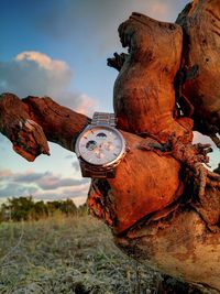 Old rusty wheel on field against sky