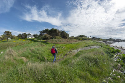 Rear view of person on field against sky