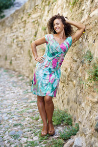 Portrait of smiling woman leaning on rock