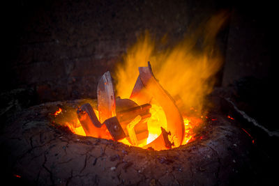 Close-up of fire on log at night