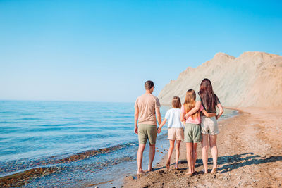 People on beach against clear sky