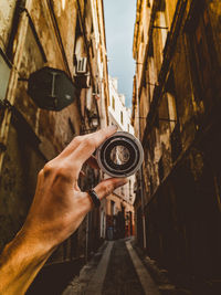 Midsection of man holding camera against sky