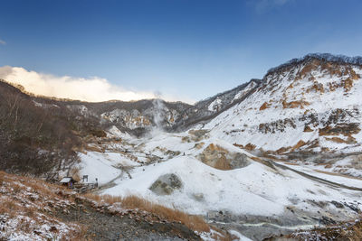 Hell valley, hokkaido, japan in winter season with blue sky, sulphur gas steam out from the ground