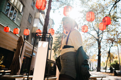 Rear view of woman standing against illuminated lantern