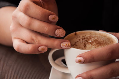 Close-up of hands holding coffee cup