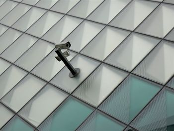 A security cam on the facade of a modern building, observing the visitors.